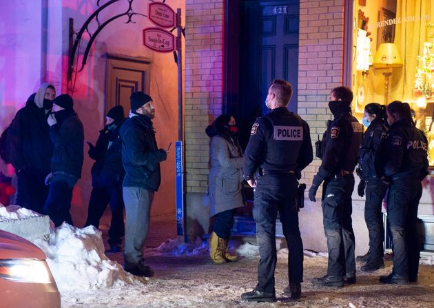 Quebec City police officers contain a handful of protestors as a curfew begins in the province to counter...