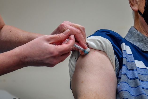 man receiving a COVID-19 vaccine. 