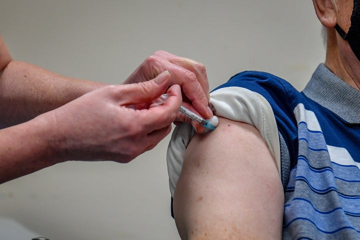 man receiving a COVID-19 vaccine. 