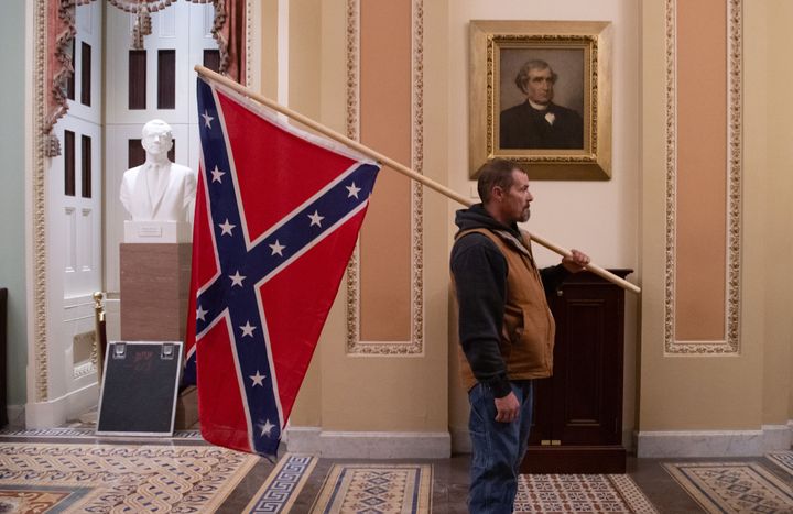  A supporter of Trump holds a Confederate flag outside the Senate Chamber during a protest after breaching the U.S. Capitol on January 6.