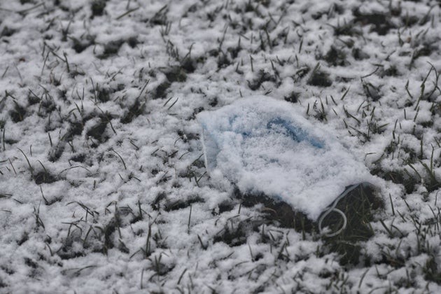 Una mascarilla, tirada en el suelo y cubierta por la