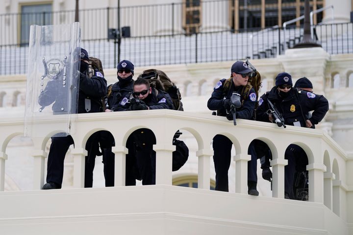Police keep a watch on demonstrators who tried to break through a police barrier, Wednesday, Jan. 6, 2021, at the Capitol in Washington. As Congress prepares to affirm President-elect Joe Biden's victory, thousands of people have gathered to show their support for President Donald Trump and his claims of election fraud. (AP Photo/Julio Cortez)