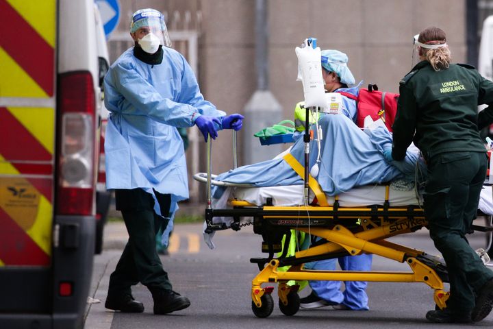 Medics wearing PPE transport a patient into the emergency department of the Royal London Hospital in London on January 11