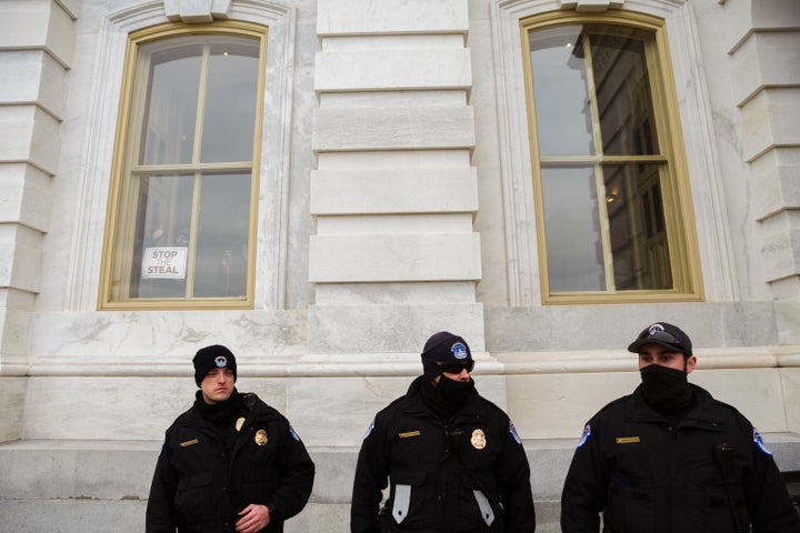 A member of a pro-Trump mob posts a "Stop the Steal" sign from inside the U.S. Capitol after breaking into it on Jan. 6.