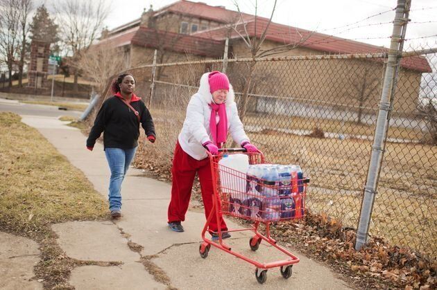 支給されたペットボトルをカートに乗せて運ぶヴァージニア・ミシェルさん（左）と義理の娘のティアラ・ウィリアムズさん（2016年2月22日）