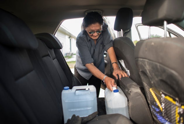 Norm Moonias fills his car with jugs of clean water in August 2019 as his home in the Neskantaga First Nation in northwestern Ontario faces a boil water advisory.