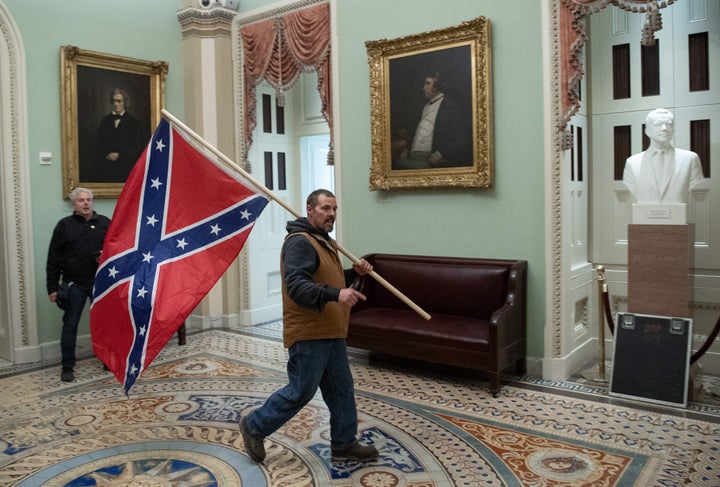 An insurrectionist parades the Confederate battle flag through the U.S. Capitol.