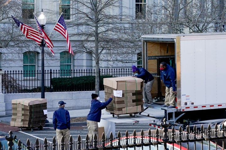 Workers unload pallets of unfolded boxes at the Executive Office Building on the White House grounds Wednesday.