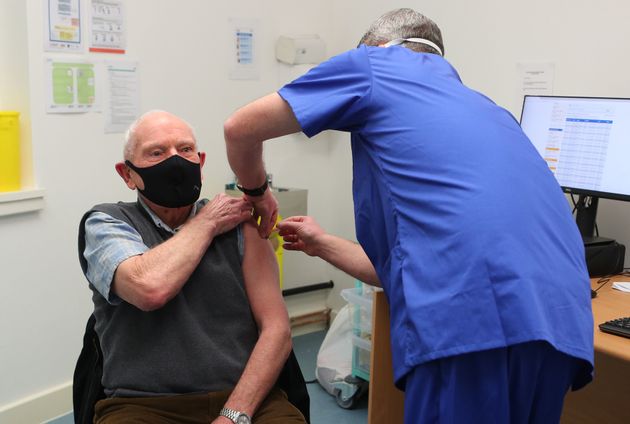 Pharmacist Andrew Hodgson administers a dose of the coronavirus vaccine to Robert Salt, 82, at Andrews Pharmacy in Macclesfield, Cheshire.