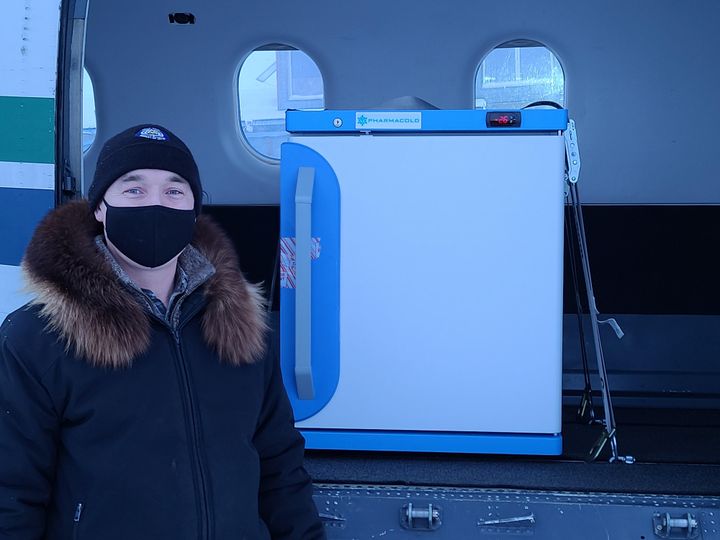 Arviat's Mayor Joe Savikataaq Jr. with the freezer containing hundreds of doses of the COVID-19 vaccine that were flown into the community on Jan. 13, 2021.
