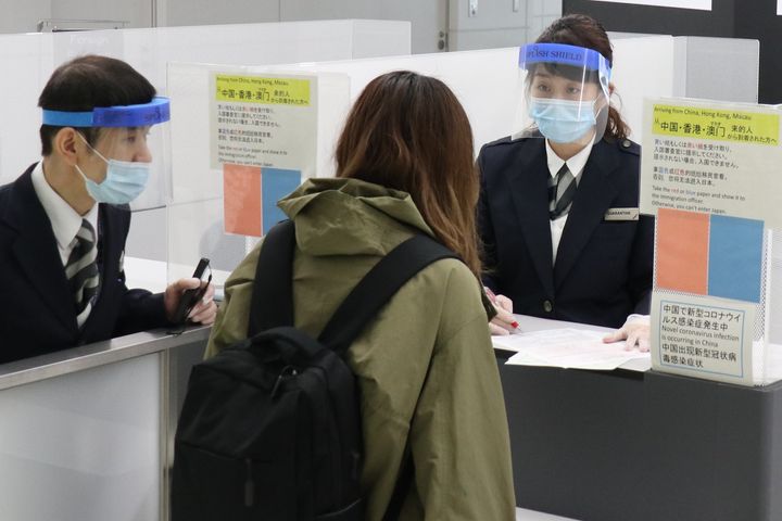 日本政府による米国からの入国制限発動で、検疫官とやり取りをする人＝2020年3月26日、千葉・成田空港