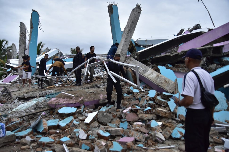 As many as 20 patients and staff are trapped beneath the rubble the Mitra Manakarra hospital in Mamuju city was flattened by 