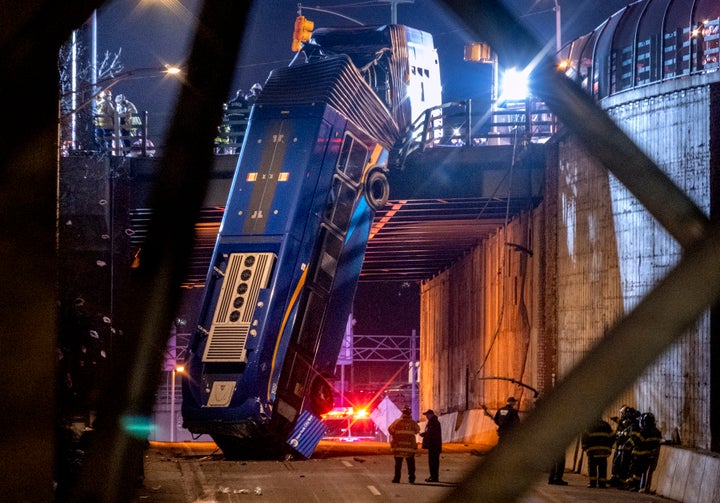 A bus in New York City which careened off a road in the Bronx neighborhood of New York is left dangling from an overpass on J