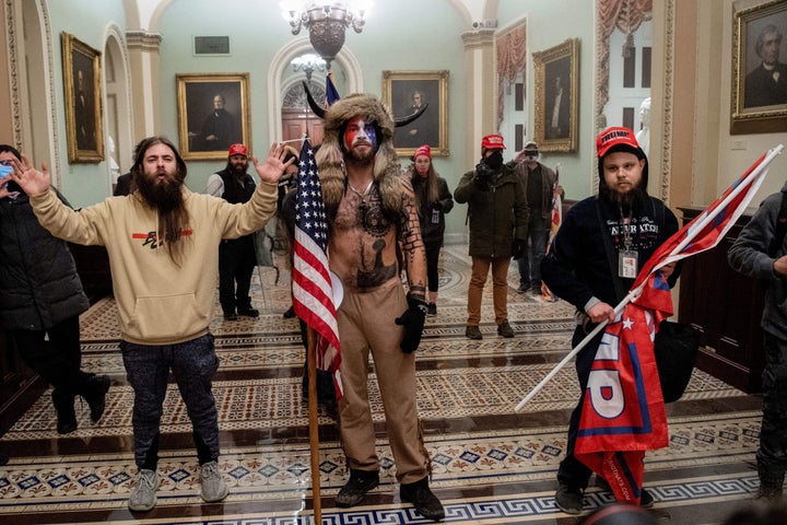 A lawyer for Jacob Chansley (center), the self-described Q Shaman, wants President Donald Trump to pardon his client because he was just following the president's orders. 