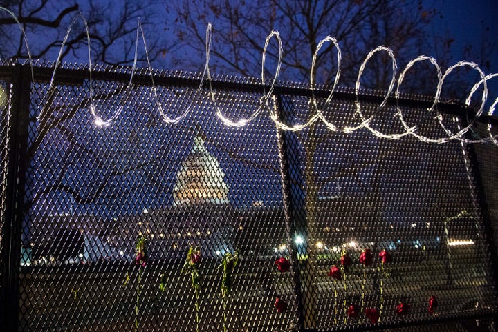 Flowers are placed along the razor wire fencing that now surrounds the U.S. Capitol on Jan. 15.