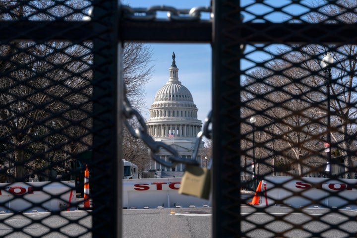 With the U.S. Capitol in the background, a lock on anti-scaling security fencing is seen on Saturday, Jan. 16, 2021, in Washi