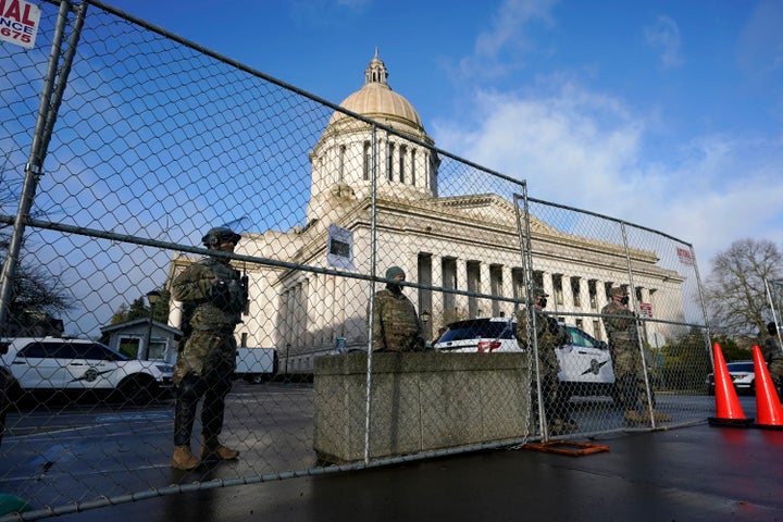 Washington National Guard members stand watch along a perimeter fence, Sunday, Jan. 17, 2021, at the Capitol in Olympia, Wash. Security is expected to remain tight at the Capitol at least through the inauguration of President-elect Joe Biden on Wednesday. (AP Photo/Ted S. Warren)