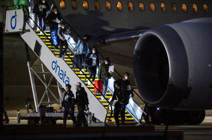 Tennis players and officials arrive on a charter flight in Melbourne on January 14, 2021, before quarantining for two weeks ahead of the Australian Open tennis tournament. 