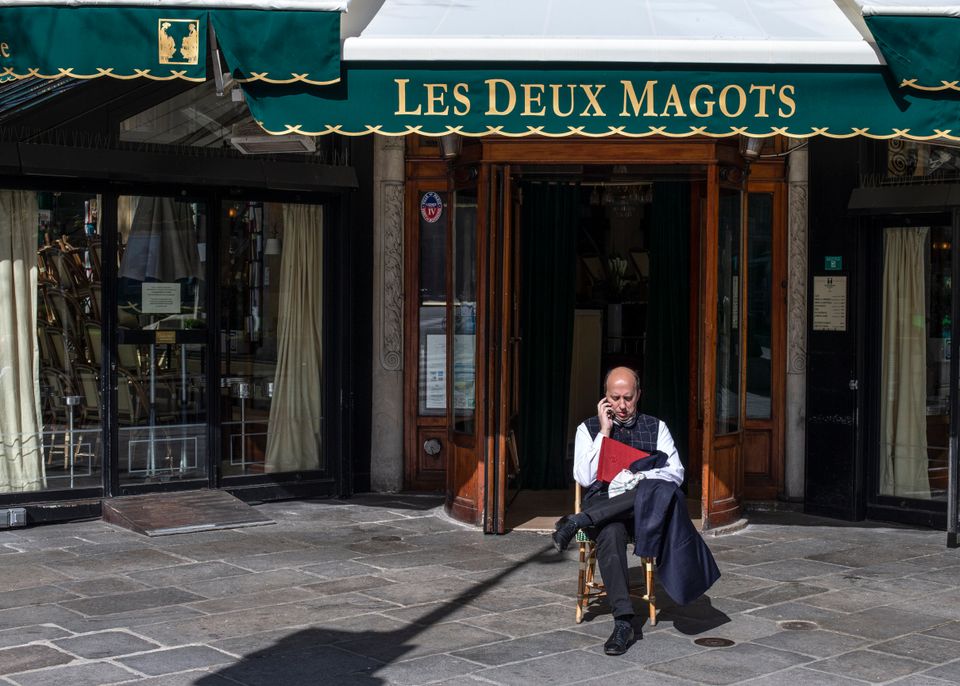 Un employé des Deux Magots à Paris le 15 mars 2020 juste après la fermeture des restaurants (AP Photo/Rafael Yaghobzadeh)