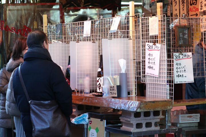 カウンターが１人向けに仕切られた上野の「アメ横」商店街にある立ち飲み屋＝1月10日、東京都台東区