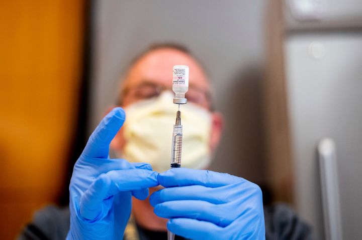 Pharmacist Brian Kiefer draws saline while preparing a dose of Pfizer's COVID-19 vaccine at UC Davis Health on Tuesday, Jan. 
