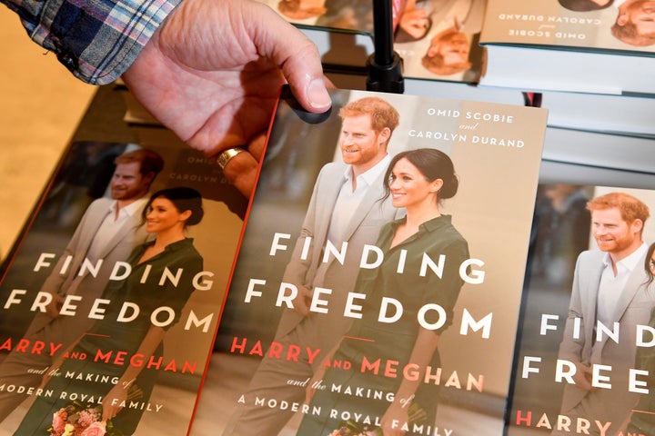 An employee holds a copy of 'Finding Freedom', an unofficial biography on Prince Harry and Meghan, the Duchess of Sussex, at a Waterstones bookshop in London on Aug. 12, 2020.