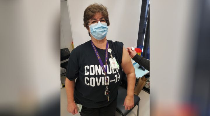 Sue McCullagh, a personal support worker in Orillia, Ont., wears her "Conquer COVID-19" T-shirt to receive a vaccine.