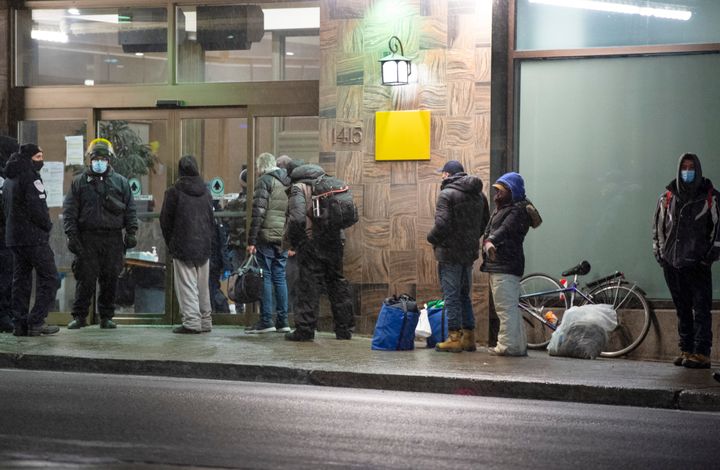 Les gens font la file devant un hôtel pour sans-abri avant 20 h, le lundi 11 janvier 2021, à Montréal.