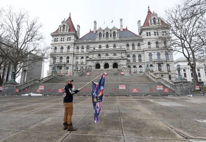 Trump supporter Mark Leggiero, of Florida, N.Y., holds a banner outside the New York state Capitol objecting to the inauguration of President Joe Biden on Wednesday.