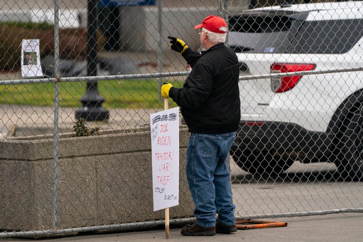 John Hess, a Donald Trump supporter, holds a sign while protesting at the Washington State Capitol on Wednesday.