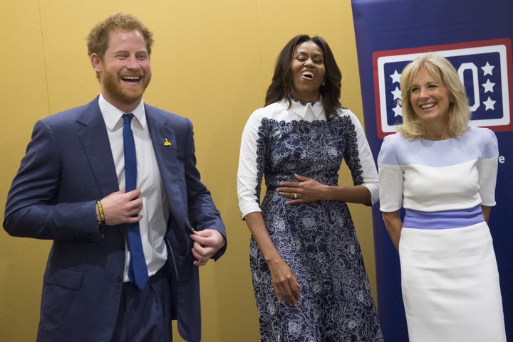 Harry, first lady Michelle Obama and Jill Biden laugh as they listen to a music presentation by wounded warriors at the USO W