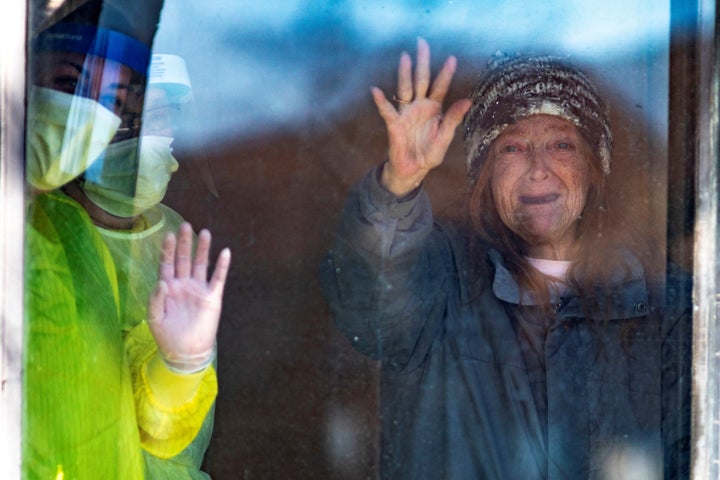 Joyce (no last name given) waves at passing cars honking their horns for support at Orchard Villa retirement and long-term care home in Pickering, Ont. on April 25, 2020. 