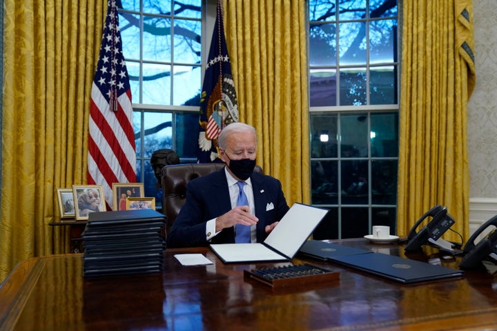 El presidente Joe Biden firma sus primeros decretos en la Oficina Oval de la Casa Blanca, el miércoles 20 de enero 2021, en Washington. (AP Foto/Evan Vucci)