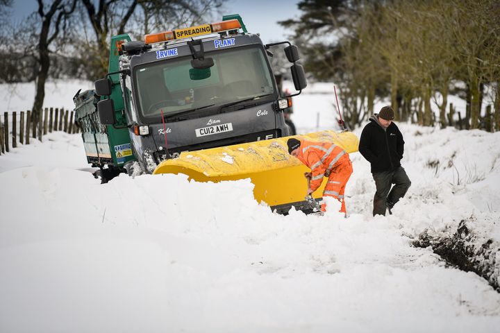 Men clear snow around a plough which had become stuck in a snow drift in Lamancha, Scotland. 