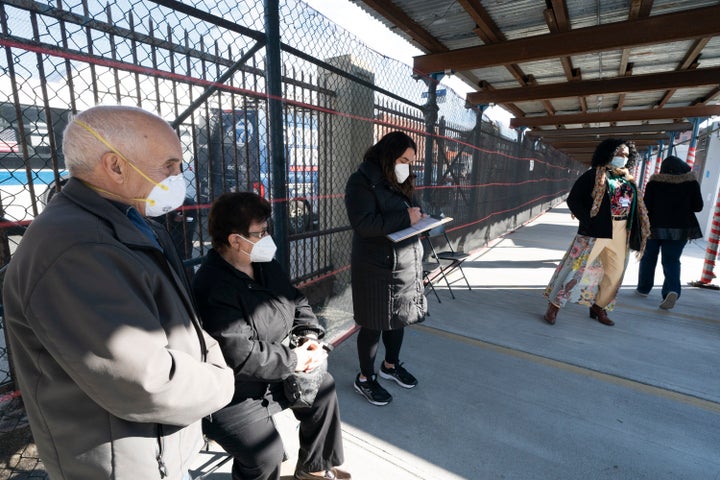 People wait in line to get vaccinated at the Brooklyn Army Terminal, on Jan. 21, 2021, in New York. Officials say 15 New York City-run COVID-19 vaccination hubs are postponing all first-dose appointments and other sites have stopped making new appointments as the city waits for more vaccine supplies. 