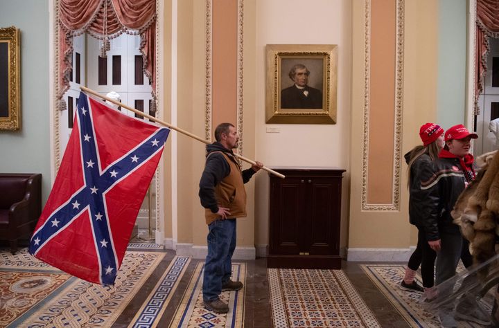 A supporter of Donald Trump holds a Confederate flag outside the Senate Chamber during a protest after breaching the US Capitol.