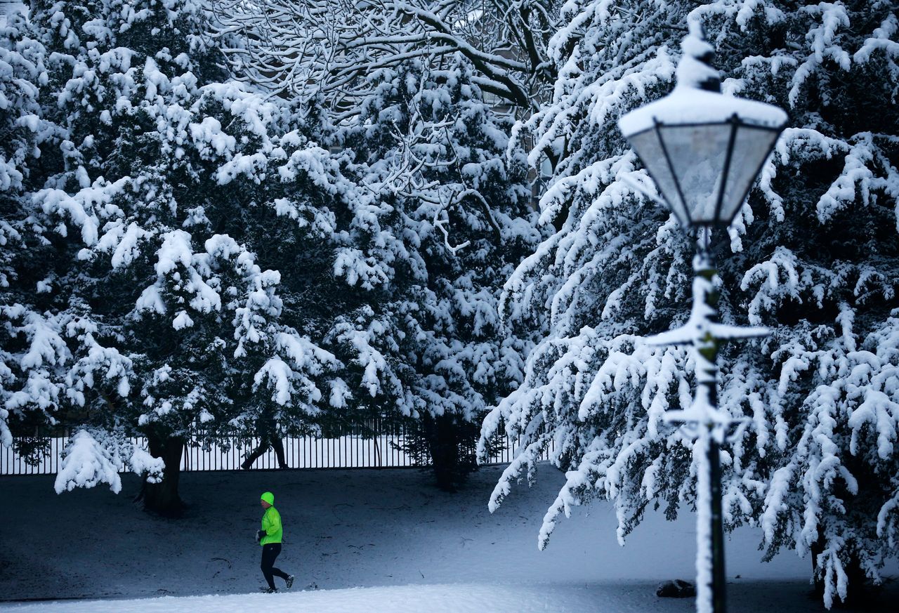 A man runs through a snow covered park in Buxton, central England.