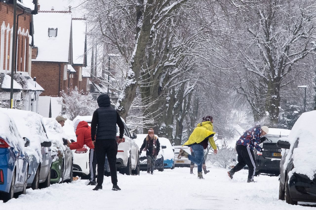 A snowball fight in the snow in Moseley, Birmingham, United Kingdom.