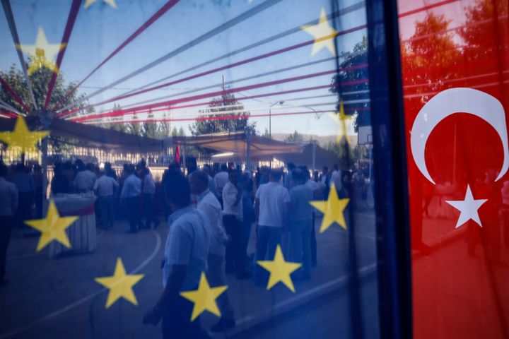 People are seen behind a European Union and a Turkish flag, as they attend an gastronomy event in Mardin, southern Turkey, Wednesday, July 11, 2018.(AP Photo/Emrah Gurel)