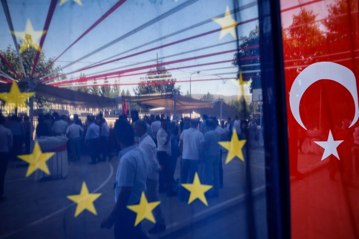 People are seen behind a European Union and a Turkish flag, as they attend an gastronomy event in Mardin, southern Turkey, Wednesday, July 11, 2018.(AP Photo/Emrah Gurel)