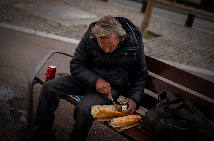 Un hombre sin hogar se prepara un bocadillo en un banco de un parque de Barcelona, el pasado 20 de enero.