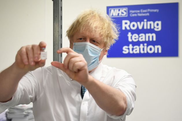 Boris Johnson holds a vial of the Oxford/Astrazeneca coronavirus vaccine
