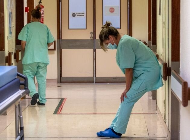 Una enfermera, exhausta, trata de descansar un instante