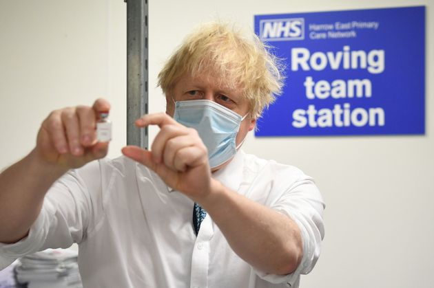 Boris Johnson holds a vial of the Oxford/AstraZeneca Covid-19 vaccine during a visit to Barnet FC's ground at The Hive, which is being used as a coronavirus vaccination centre, in north London.