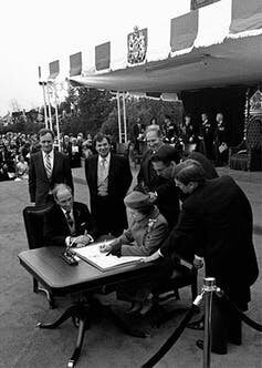 Queen Elizabeth signs Canada’s constitutional proclamation in Ottawa on April 17, 1982, as Prime Minister Pierre Trudeau and other government officials look on. The patriation of the Constitution maintained the position of Governor General as the Queen’s representative in Canada.