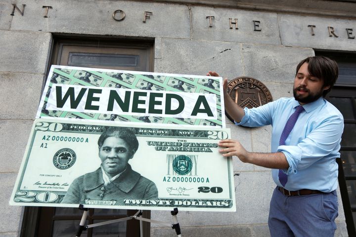 In 2019, a Capitol Hill staff member places signs before a news conference by House Majority Leader Steny Hoyer (D-M.D.) on then-Treasury Secretary Steve Mnuchin's decision to indefinitely delay putting Harriet Tubman on the new $20 bill.