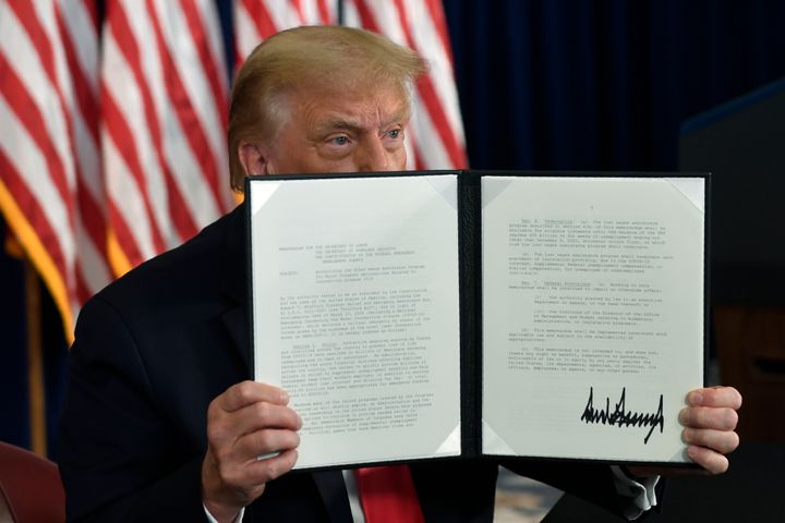 President Donald Trump signs an executive order during a news conference at the Trump National Golf Club in Bedminster, New Jersey, on Aug. 8, 2020.