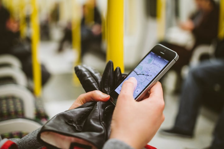 Una persona usando su teléfono en el transporte público.