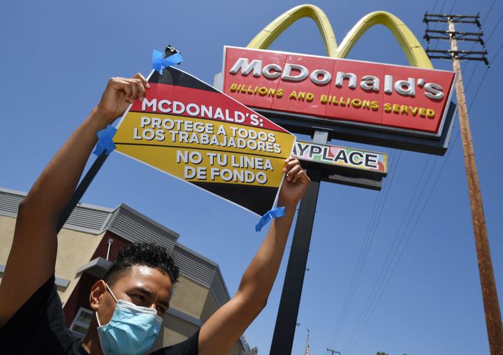 Workers protest outside a California McDonald's over alleged unsafe working conditions in the pandemic. A new study shows that essential workers like cooks are more likely to die of COVID-19 than other workers.