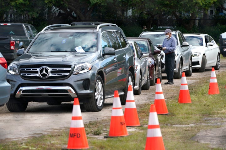 People in their vehicles are checked in at a drive-thru COVID-19 vaccination site at Marlins Park on Thursday in Miami.